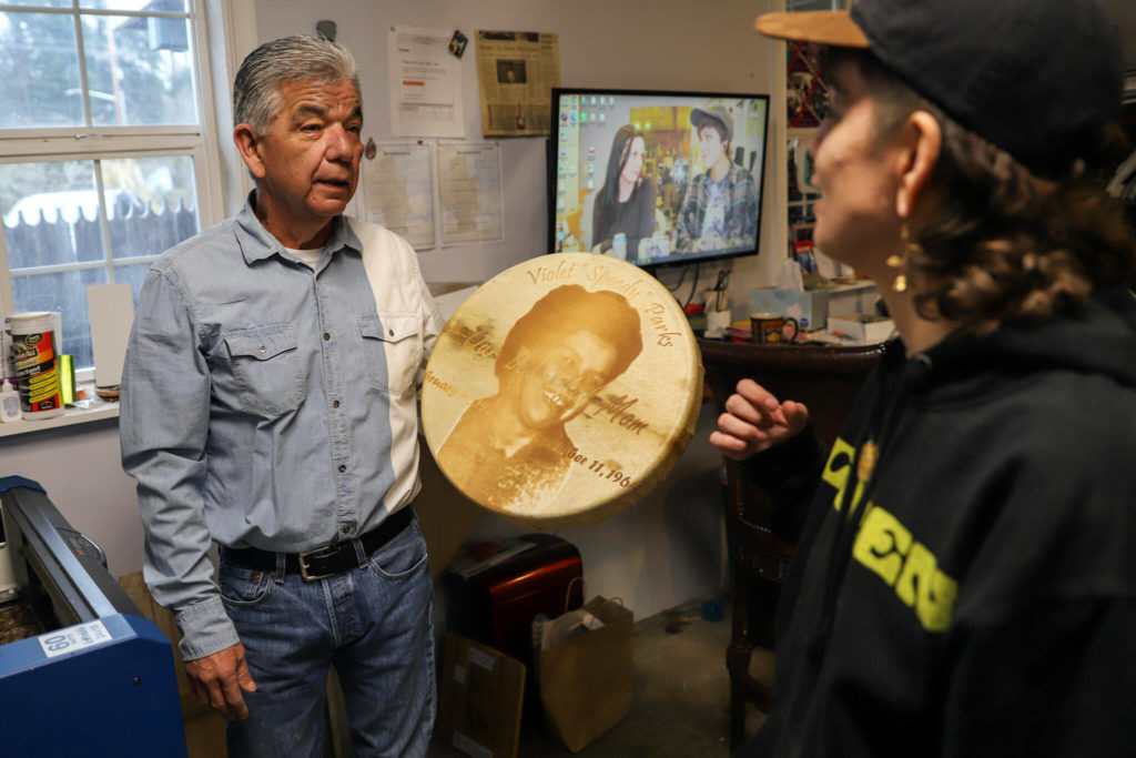 Les Parks (left) talks with his daughter Kenzi Parks after a laser-etched drum finished printing Tuesday afternoon at his home in Tulalip. (Kevin Clark / The Herald)
