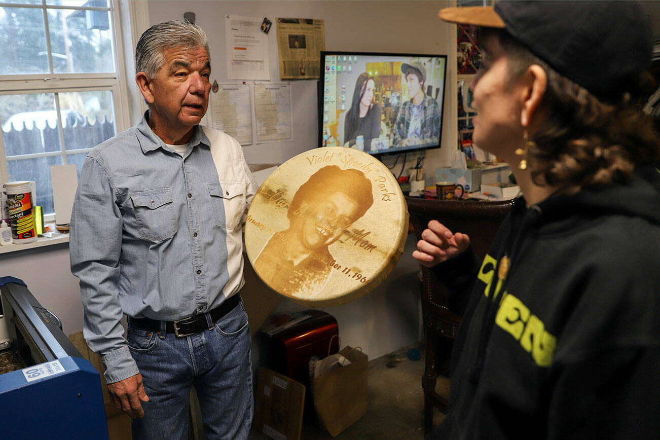 Les Parks, left, talks with his daughter, Kenzi Parks, after a laser etched drum finished printing Tuesday afternoon at his home in Tulalip, Washington on January 25, 2022. (Kevin Clark / The Herald)