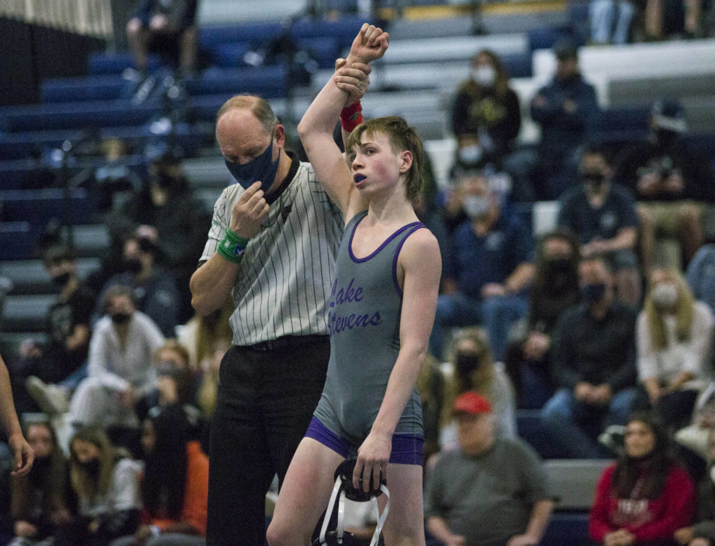 Lake Stevens’ Jacob Christianson has his hand raised after his win helps seal the match for Lake Stevens on Tuesday in Snohomish. (Olivia Vanni / The Herald)
