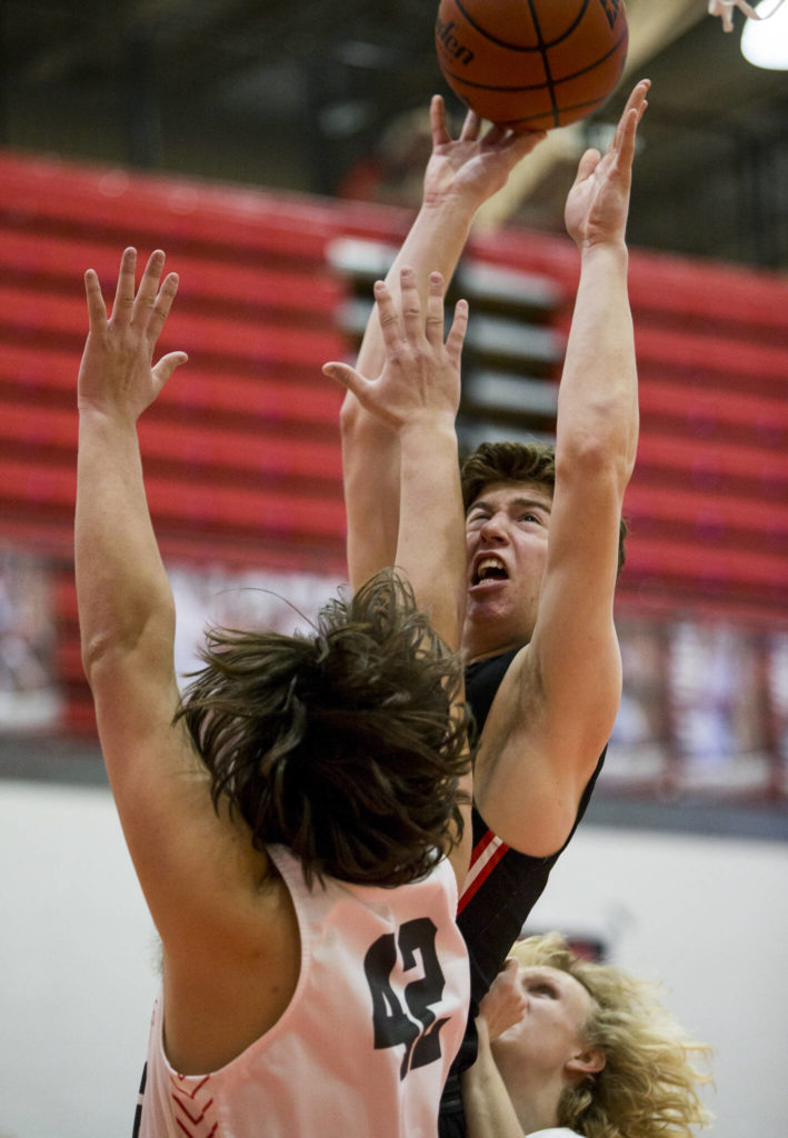 Mountlake Terrace’s Adison Mattix attempts a layup over Stanwood’s Kolten Bartram-Scott during Thursday’s game in Stanwood. (Olivia Vanni / The Herald)
