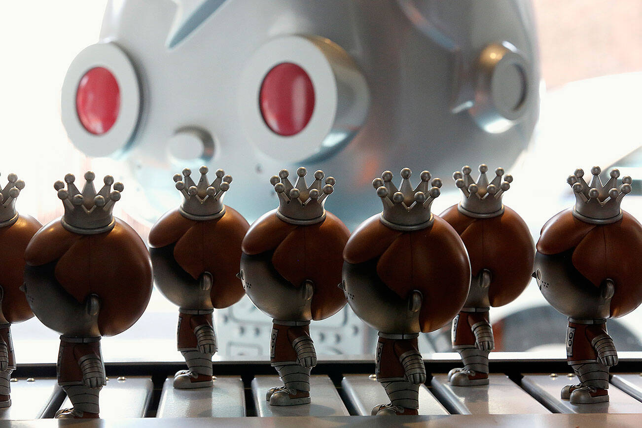 Funko mascots Freddy Funko roll past on a conveyor belt in the Pop! Factory of the company's new flagship store on Aug. 18, 2017.  (Dan Bates / The Herald)