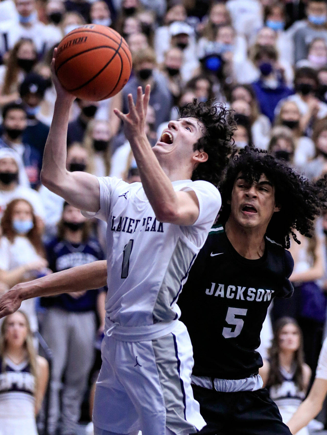 Glacier Peak’s Aidan Davis attempts a layup with Jackson’s Sylas Williams trailing Friday evening at Glacier Peak High School in Snohomish, Washington on January 21, 2022. The Grizzles won 57-54. (Kevin Clark / The Herald)