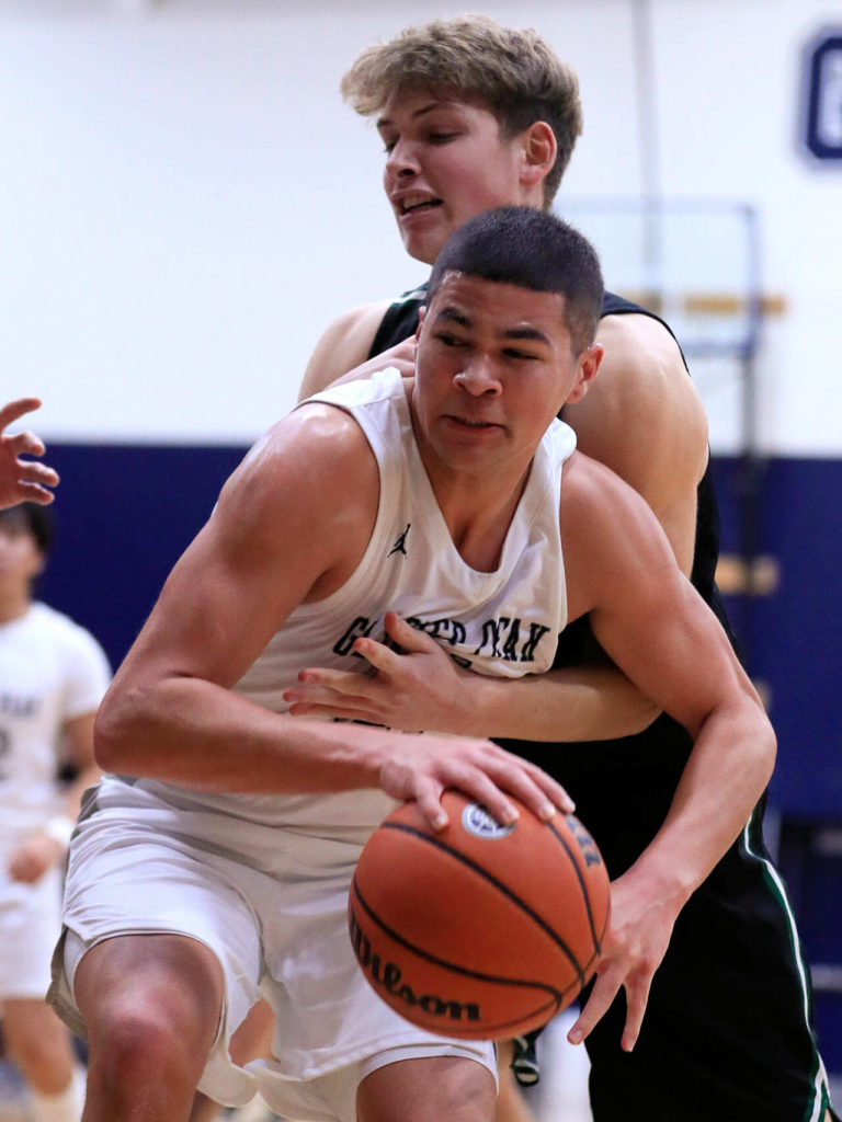 Glacier Peak’s Torey Watkins gathers a rebound with Glacier Peak’s Jo Lee reaching in Friday evening at Glacier Peak High School in Snohomish, Washington on January 21, 2022. The Grizzles won 57-54. (Kevin Clark / The Herald)
