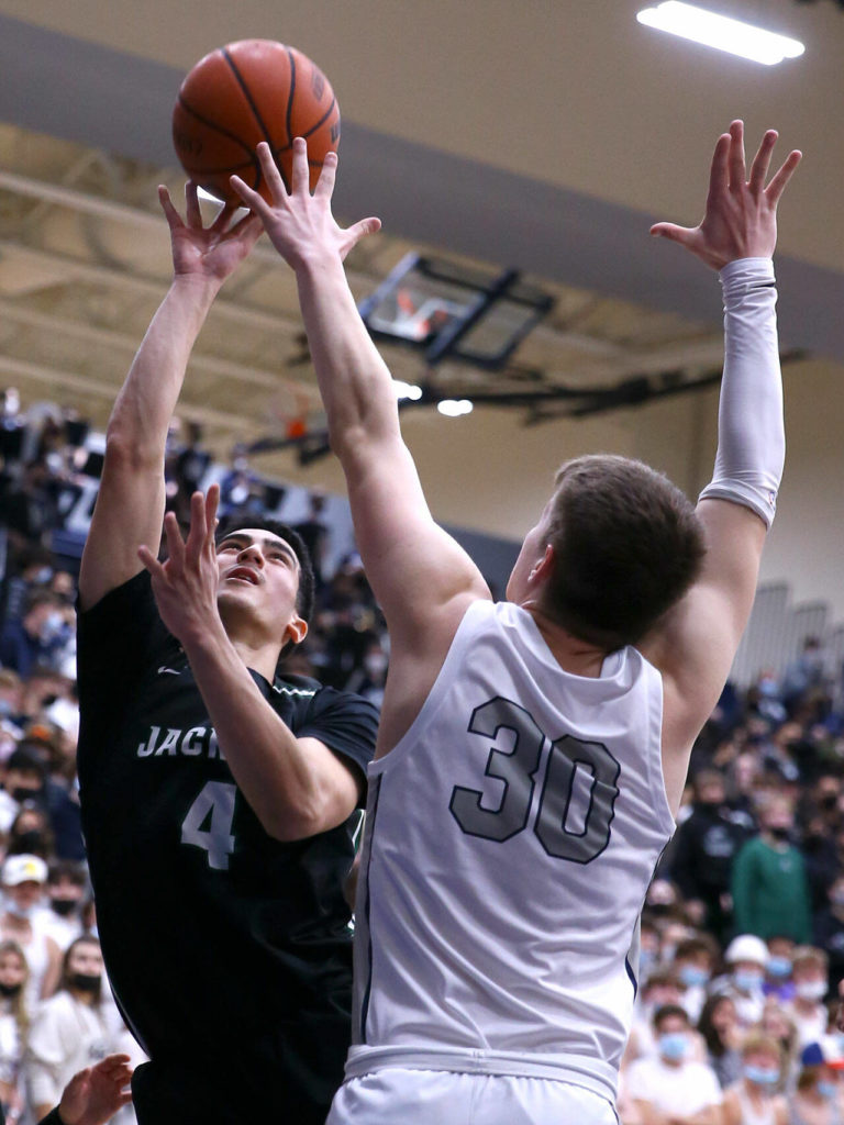 Jackson’s Bradley Tharp attempts a shot over Glacier Peak’s Bobby Siebers Friday evening at Glacier Peak High School in Snohomish, Washington on January 21, 2022. The Grizzles won 57-54. (Kevin Clark / The Herald)
