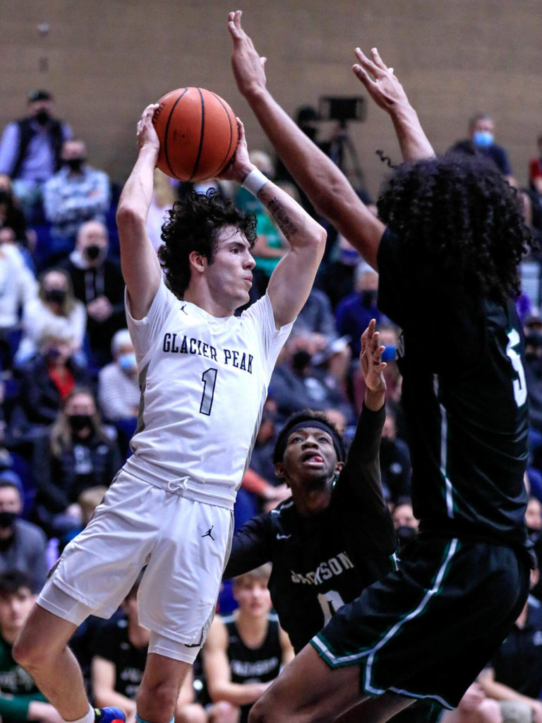 Glacier Peak’s Aidan Davis looks to pass with Jackson’s Evan Bates, center, and Sylas Williams defending Friday evening at Glacier Peak High School in Snohomish, Washington on January 21, 2022. The Grizzles won 57-54. (Kevin Clark / The Herald)
