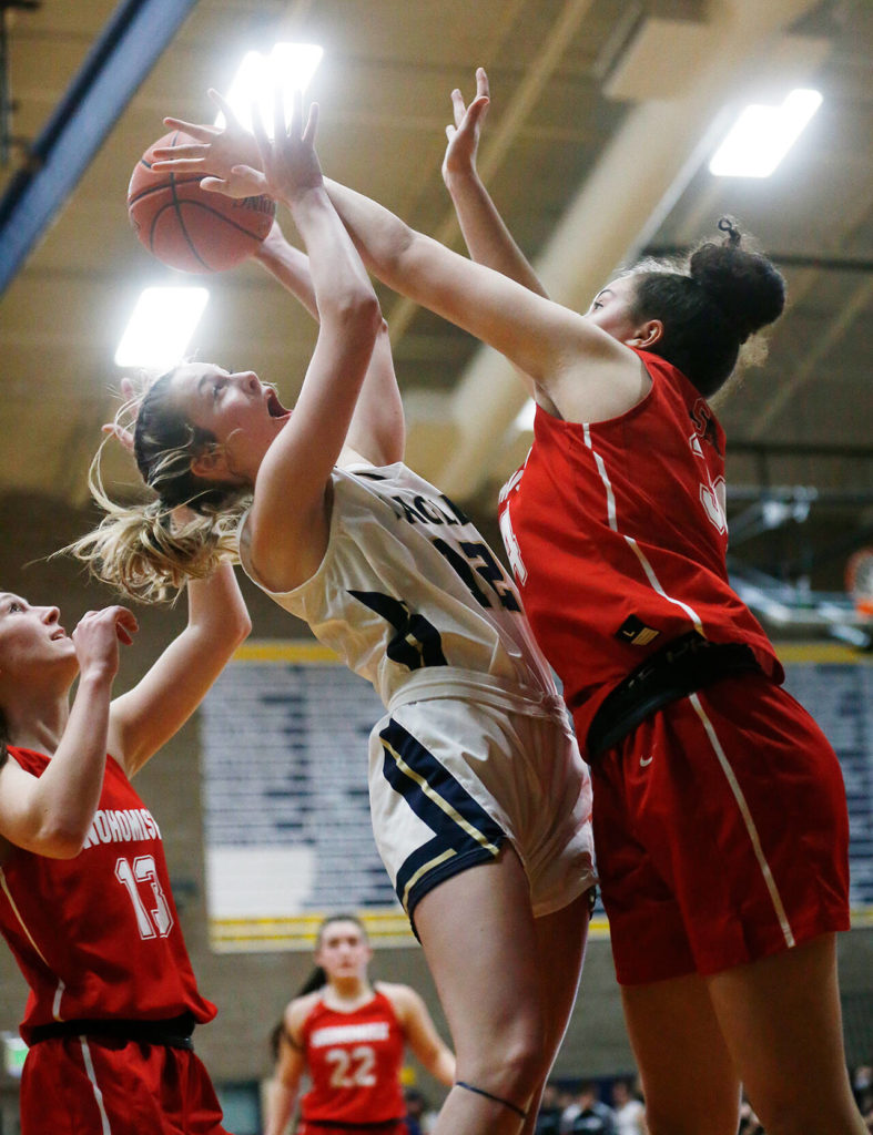 Arlington senior Hannah Rork (left) draws a foul during the Eagles’ 57-44 win over Snohomish on Monday night. (Ryan Berry / The Herald)
