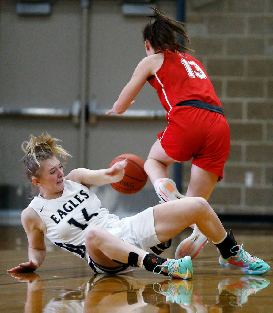 Arlington’s Keira Marsh and Snohomish’s Ella Gallatin chase after a loose ball during a game Monday at Arlington High School. (Ryan Berry / The Herald)
