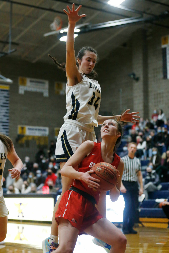 Snohomish’s Ella Gallatin gets the defender in the air before scoring and getting fouled during a game on Monday at Arlington High School. (Ryan Berry / The Herald)
