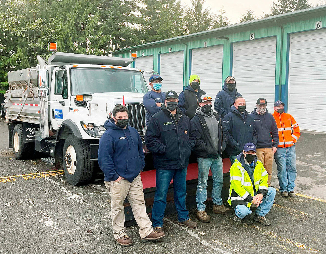 Lynnwood Public Works employees in front of one of the city’s two plows that will be named based on results of an online public vote. (City of Lynnwood)