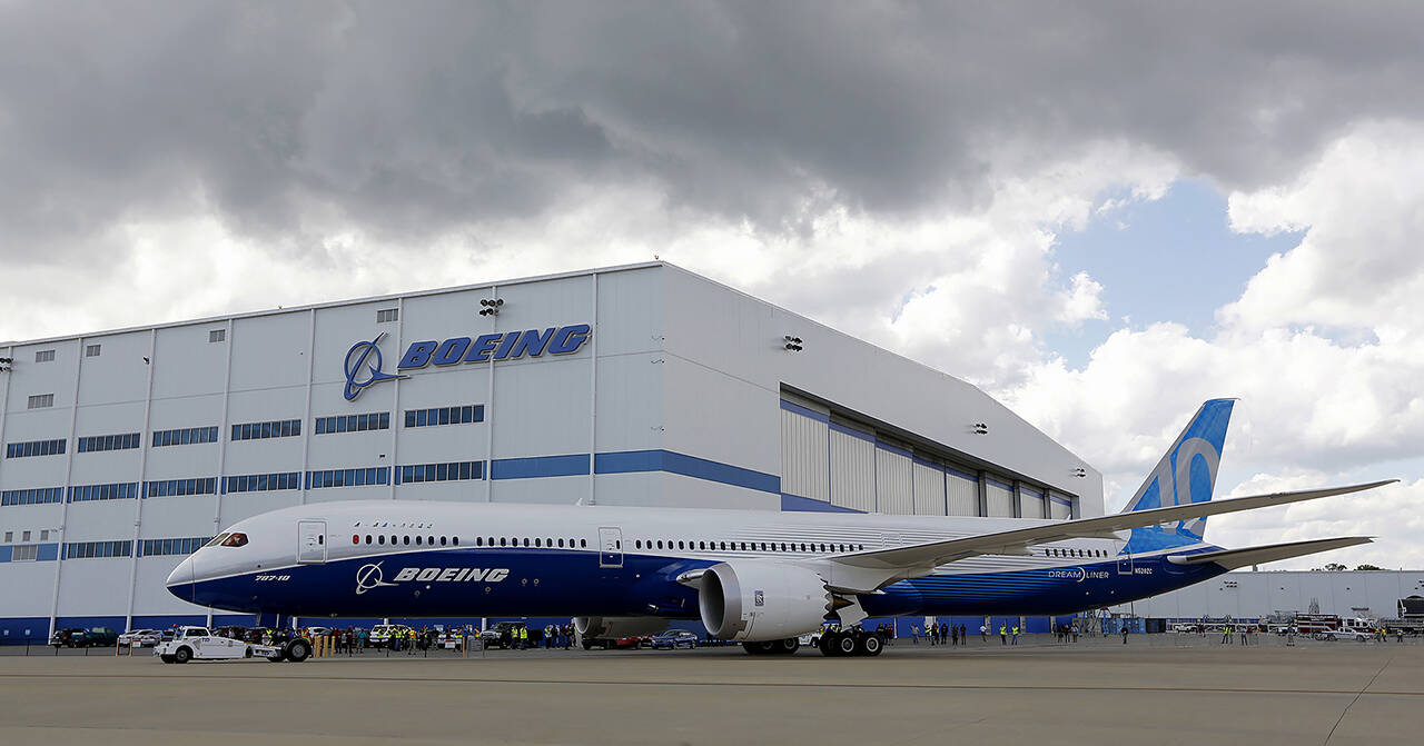 In this 2017 photo, Boeing employees stand near the new Boeing 787-10 Dreamliner at the company’s facility in South Carolina after conducting its first test flight at Charleston International Airport in North Charleston, South. Carolina. (AP Photo/Mic Smith, File)