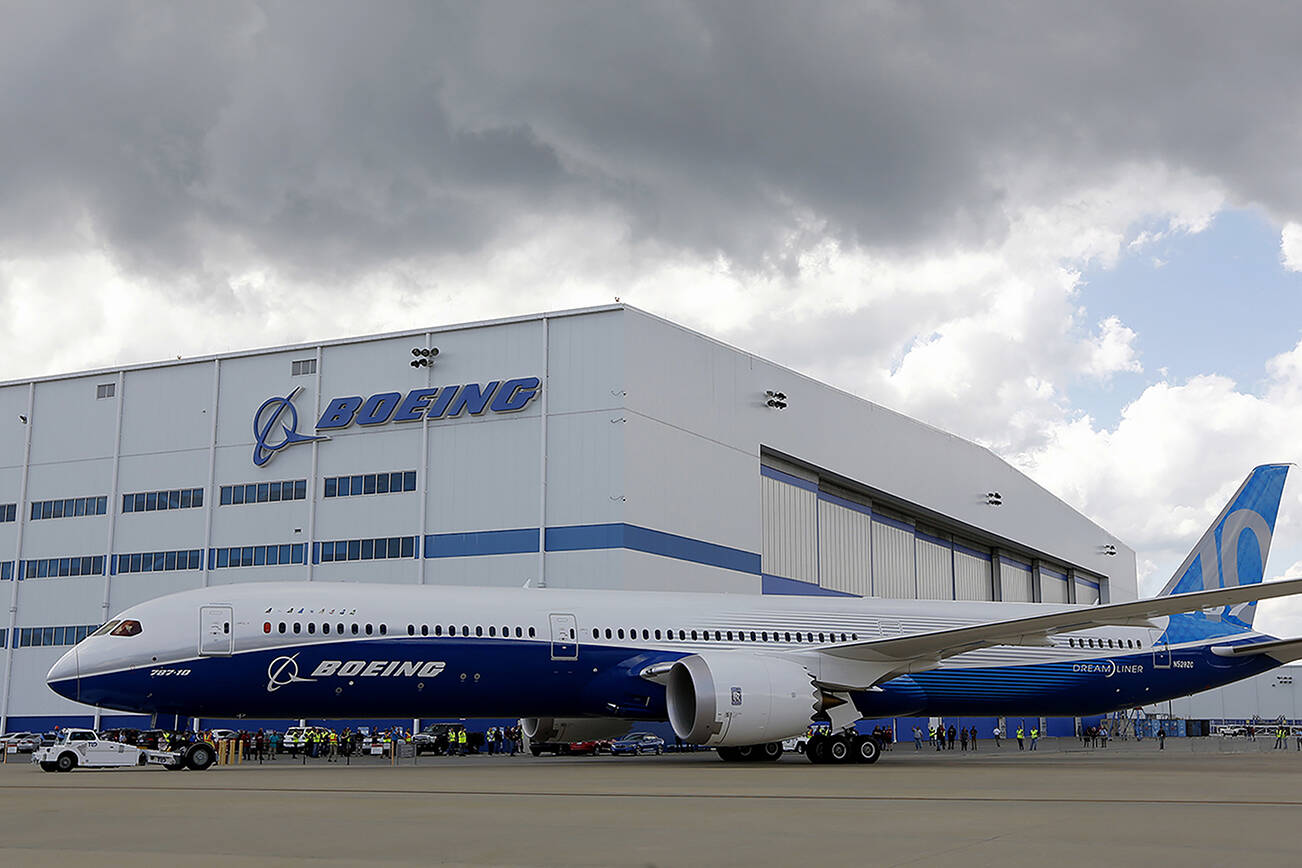 FILE - In this March 31, 2017, file photo, Boeing employees stand near the new Boeing 787-10 Dreamliner at the company's facility in South Carolina after conducting its first test flight at Charleston International Airport in North Charleston, S.C.  The International Association of Machinist says six of its earliest and most vocal members have been fired at Boeing’s South Carolina plant, months after some employees at the sprawling North Charleston campus voted to join the union.  The Machinists tell The Associated Press that half a dozen employees were terminated from the North Charleston production facilities earlier in 2018. (AP Photo/Mic Smith, File)