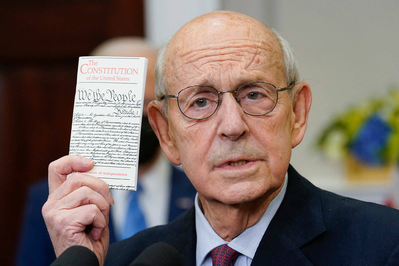 Supreme Court Justice Stephen Breyer holds up a copy of the United States Constitution as he announces his retirement in the Roosevelt Room of the White House in Washington, Jan. 27. (Andrew Harnik / Associated Press)