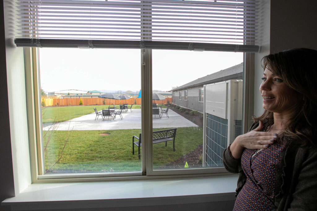 Angela Pearson reacts after seeing chairs set up outside for the first time Friday at the new Holman Recovery Center in Smokey Point. (Ryan Berry / The Herald)
