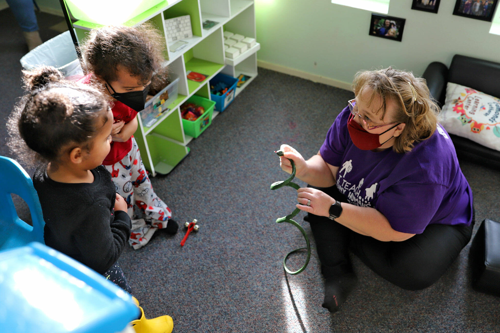 AJ (left), 2, and Antonio, 3, recoil from a toy snake held by Dani Hanson-Hooten on Jan. 28 at the Edmonds Lutheran Learning Center. (Kevin Clark / The Herald)