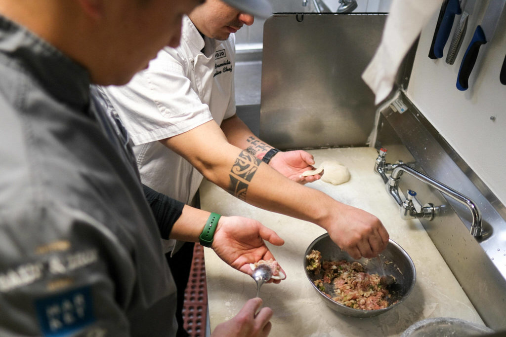 Bar Dojo’s chef-owner Shubert Ho (left) and chef de cuisine Luis Brambila fill and shape dumplings on Monday. (Taylor Goebel / The Herald)
