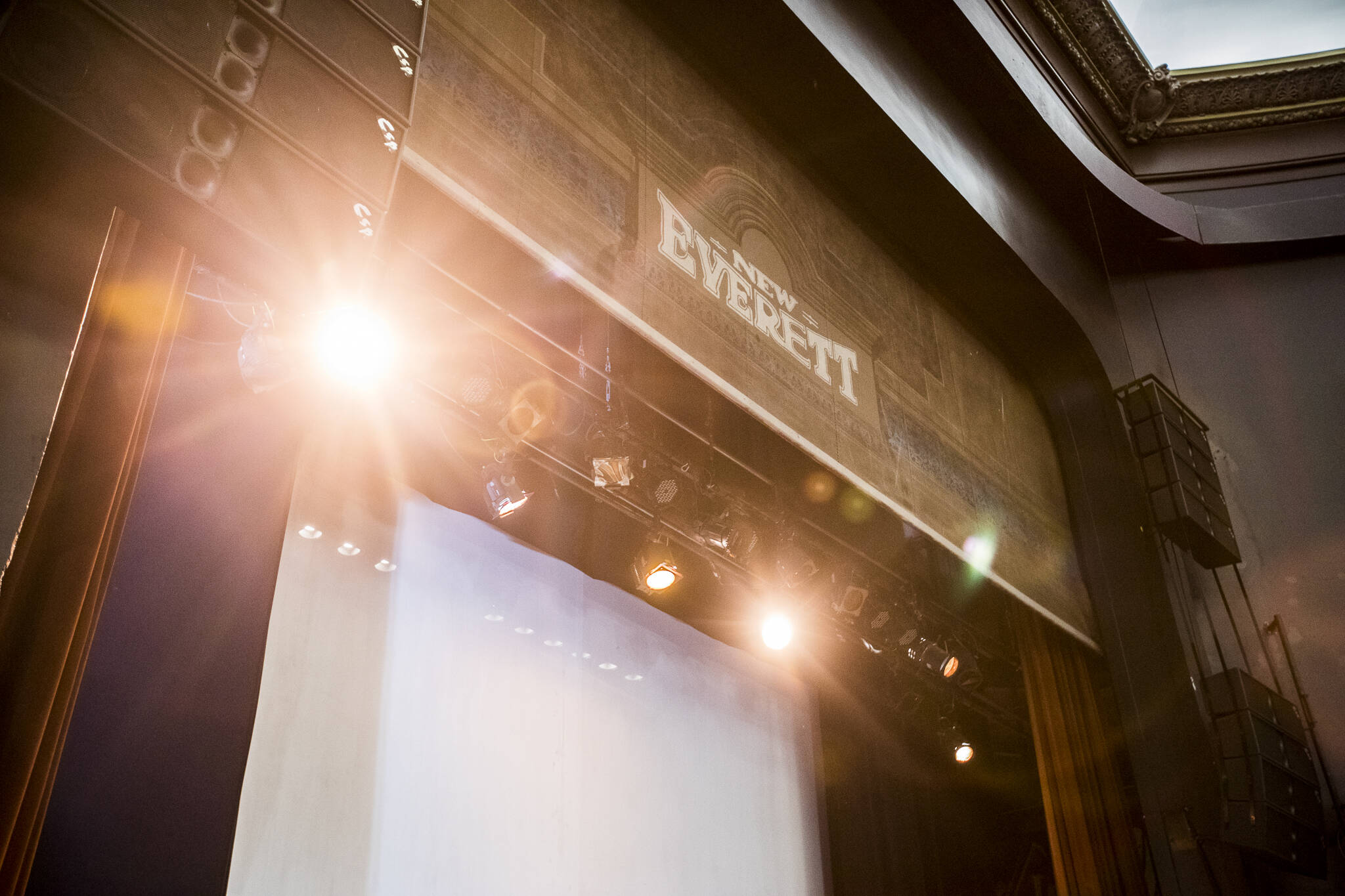 Stage lights illuminate the New Everett banner above the stage at the Historic Everett Theatre. (Olivia Vanni / The Herald)