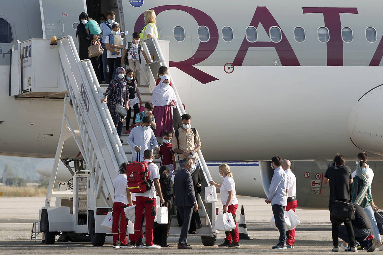 Afghan evacuees disembark the plane and board a bus after landing at Skopje International Airport, North Macedonia, on Wednesday, Sept. 15, 2021. North Macedonia has hosted another group of 44 Afghan evacuees on Wednesday where they will be sheltered temporarily till their transfer to final destinations. (AP Photo/Boris Grdanoski)