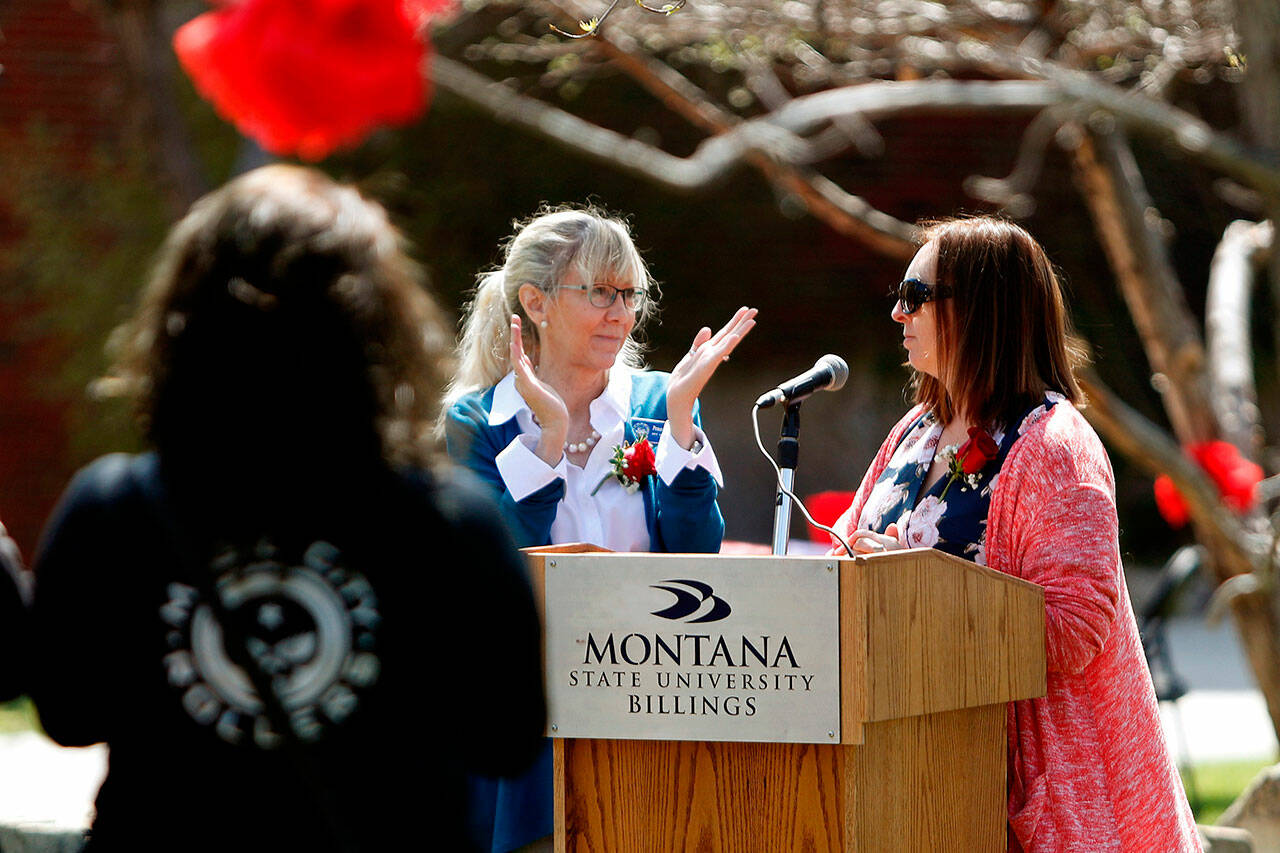 Penny Ronning, center, applauds trafficking survivor Savannah J. Sanders for inspiring the Billings organizers of the Red Sand Project at Peaks to Plains Park at MSU Billings on April 25, 2019, in Billings, Mont. Ronning says sex trafficking and related crimes have long been present in the state but there’s more focus on fighting the problem. (Casey Page / The Billings Gazette via AP)