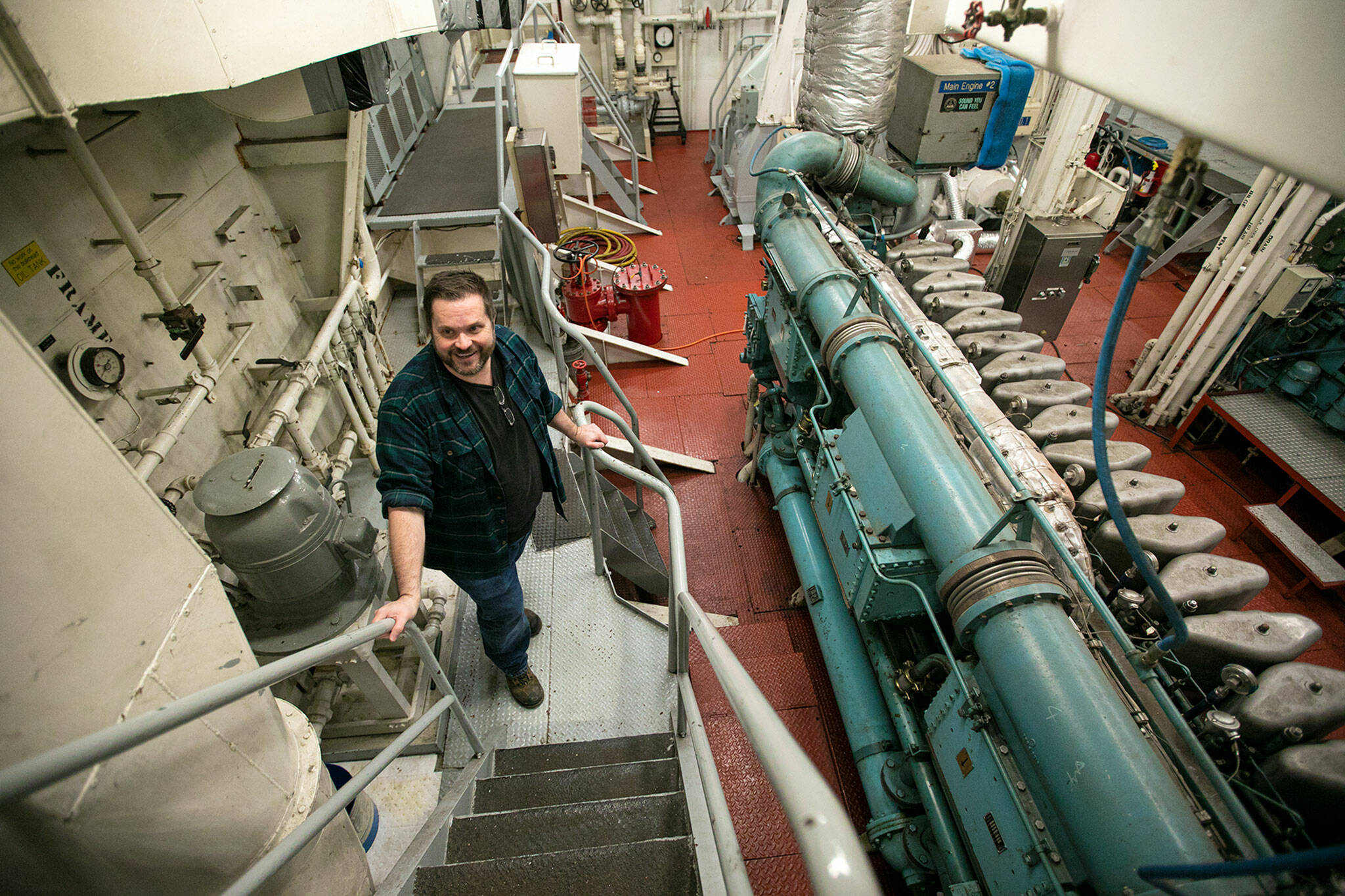 Bart Lematta proudly stands in the engine room of his ferry, the Evergreen State, a former longtime state workhorse that he purchased at auction in 2020 for $290,000. “I can picture all the work that’s gone into it and all the hands that have been part of building it, the artistry and craftsmanship,” he said. “It’s a beautiful piece of artwork.” (Ryan Berry / The Herald)