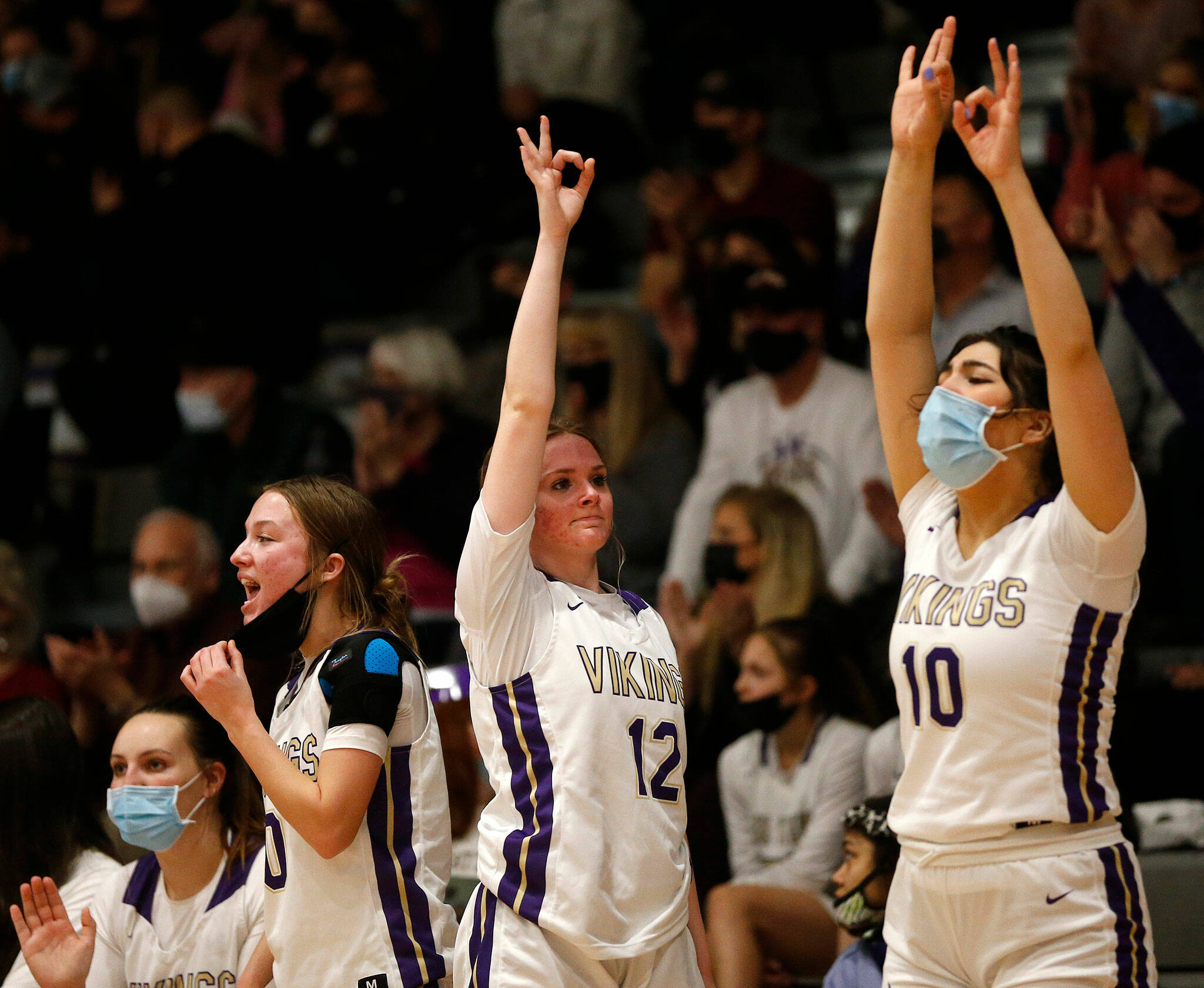 The Lake Stevens bench reacts to a teammate’s 3-point shot during a game against Kamiak on Feb. 7, 2022, at Lake Stevens High School. (Ryan Berry / The Herald)