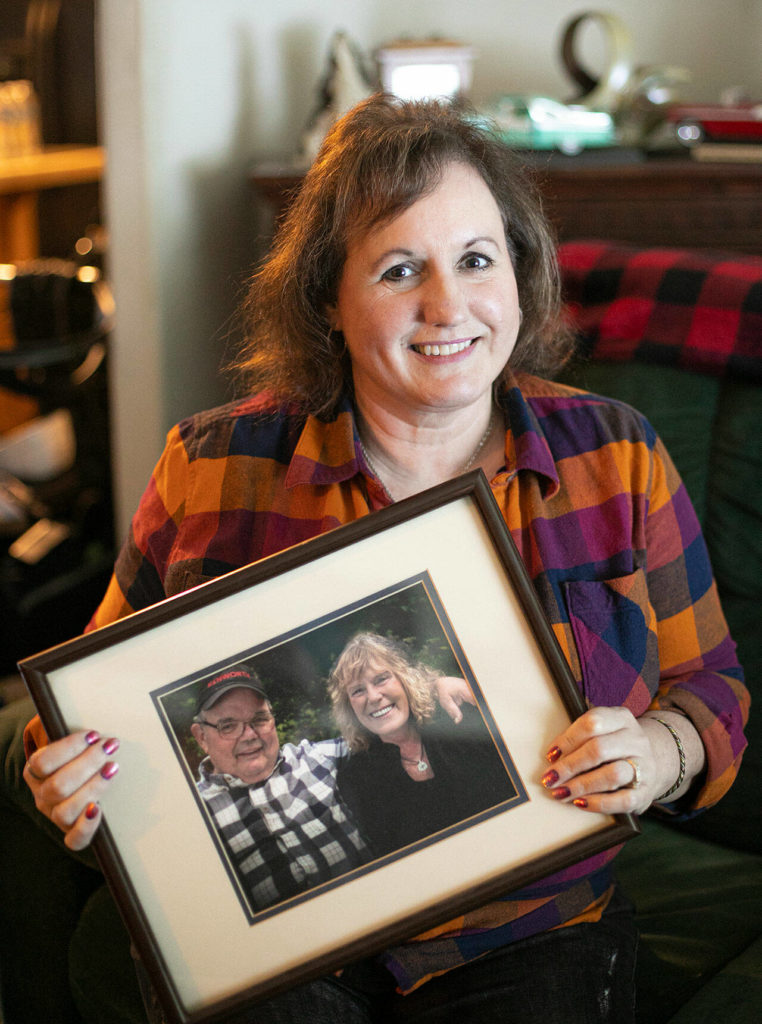 Diane Altman Jennings holds a photo of her father, Jerry Dinsmore, and his wife, Andrea. (Ryan Berry / The Herald) 
