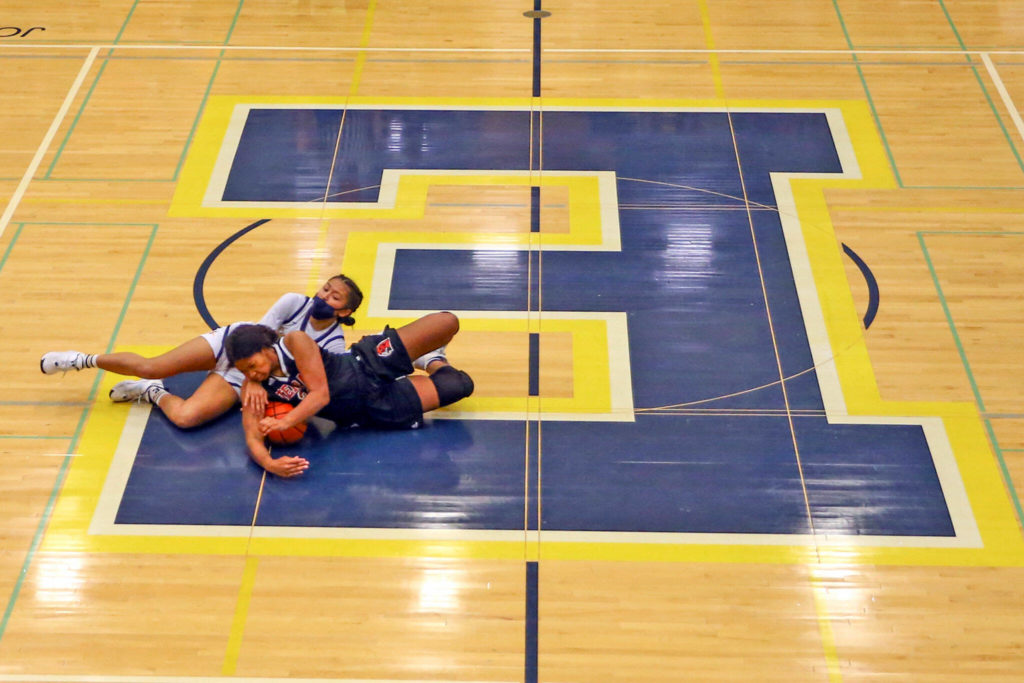 Everett’s Andrea Parrish, left, and Mountlake Terrace’s Sierra Sonko wrestle for a loose ball Friday evening in Everett, Washington on February 11, 2022. (Kevin Clark / The Herald)

