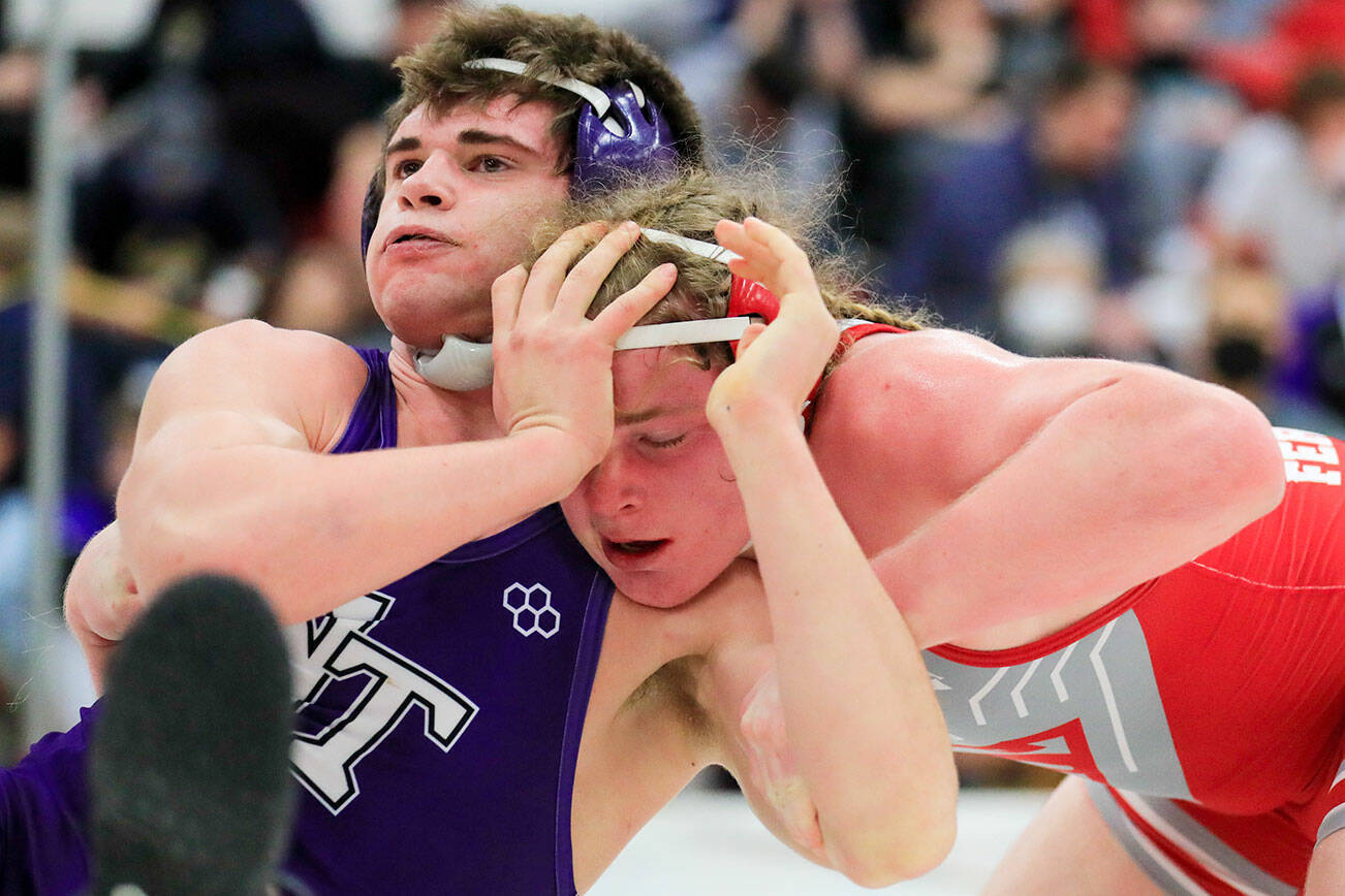 North Thurston’s Bruce Price attempts to fend off Stanwood’s Mason Ferguson Saturday evening during the 3A Regional 1 boys wrestling tournament at Snohomish High School in Snohomish, Washington on February 12, 2022.  (Kevin Clark / The Herald)