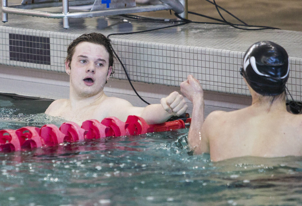 Lake StevensՠGarrett Chesley fist bumps Reece Gerhart after winning the the 100 Yard Backstroke during the 4A Boys Districts swim meet on Saturday, Feb. 12, 2022 in Snohomish, Wa. (Olivia Vanni / The Herald)
