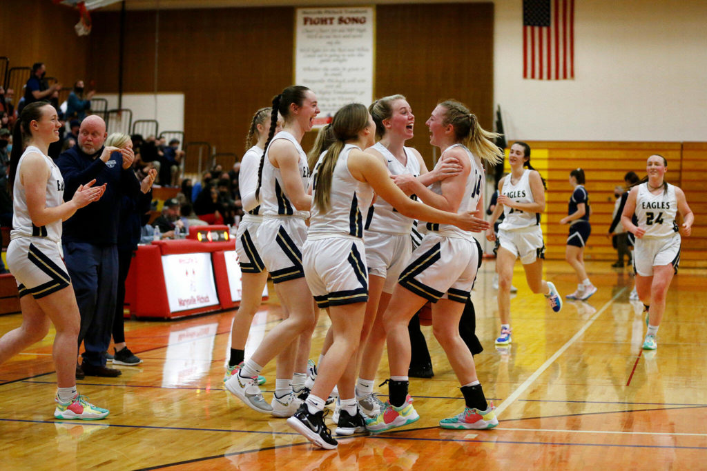 The Arlington girls begin to celebrate after fending off a late run by Everett Tuesday, Feb. 15, 2022, at Marysville Pilchuck High School in Marysville, Washington. (Ryan Berry / The Herald)
