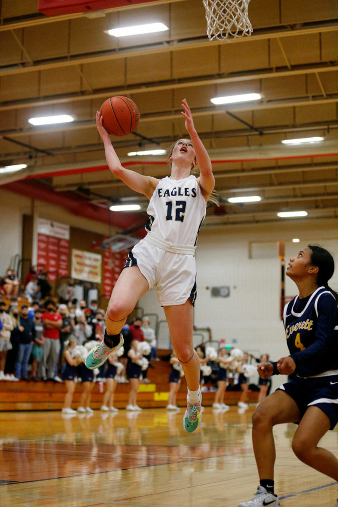 Arlington’s Hannah Rork finishes off a play in transition against Everett Tuesday, Feb. 15, 2022, at Marysville Pilchuck High School in Marysville, Washington. (Ryan Berry / The Herald)
