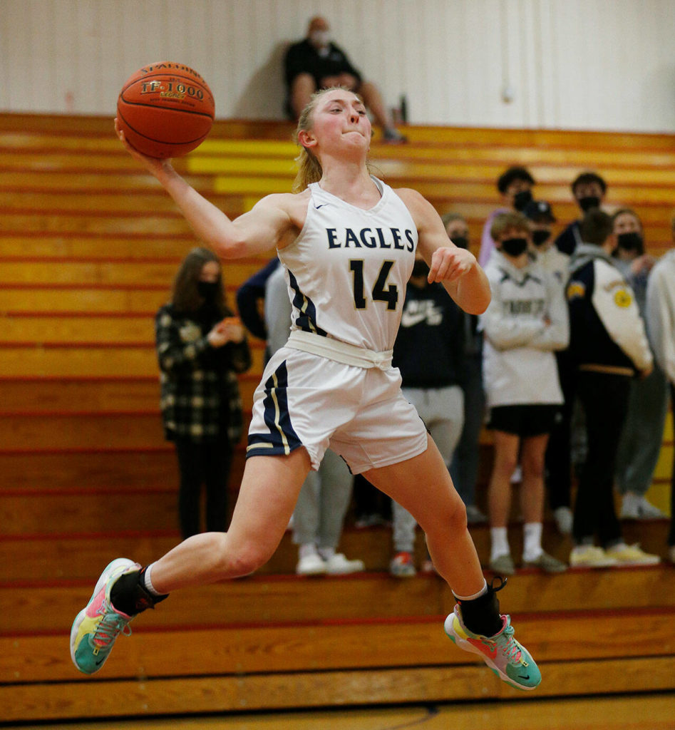 Arlington’s Keira Marsh saves a ball from going out of bounds against Everett Tuesday, Feb. 15, 2022, at Marysville Pilchuck High School in Marysville, Washington. (Ryan Berry / The Herald)
