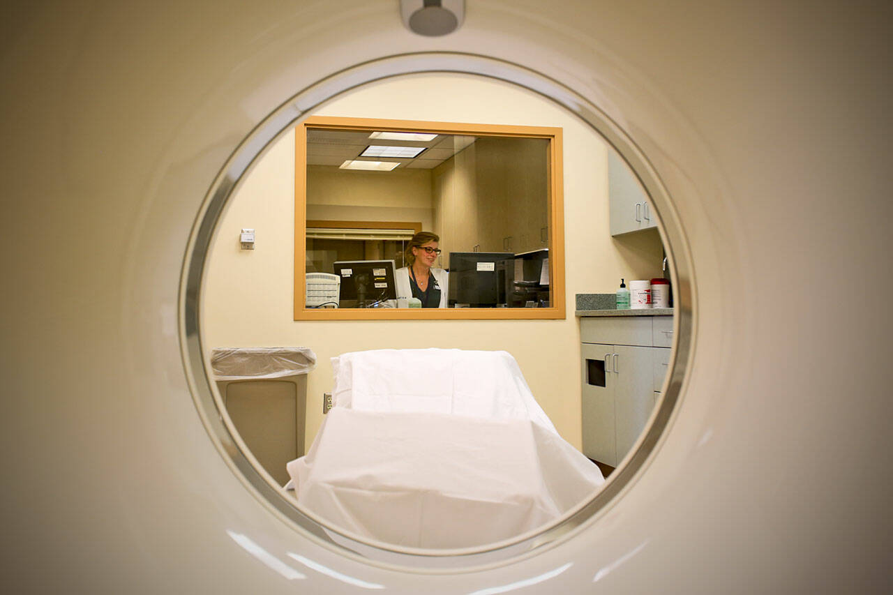Rita Mangum, a CT technologist, sits at her station at the Western Washington Medical Group imaging center in Everett in September 2016. (Kevin Clark / The Herald file photo)