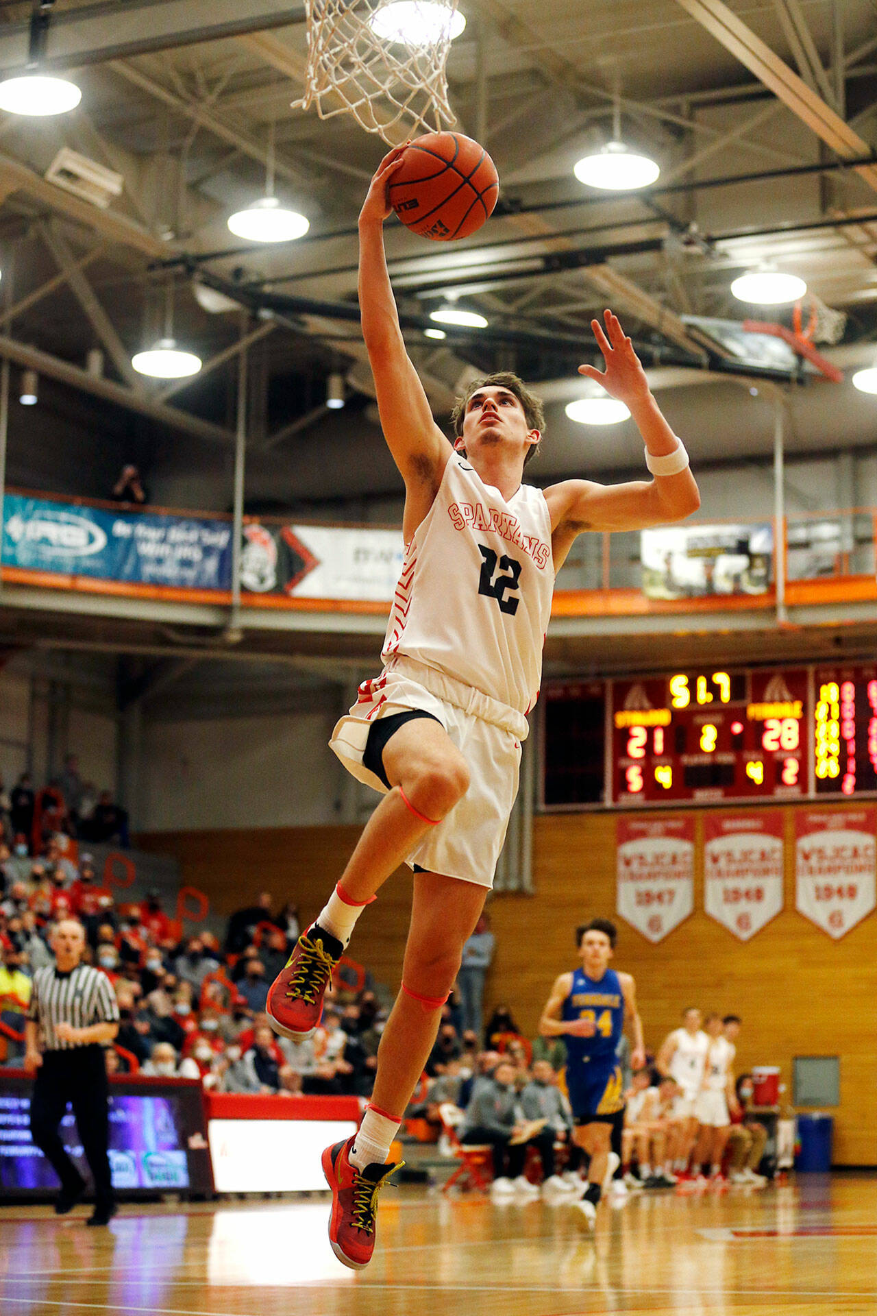 Stanwood’s Mack Hepper takes flight while dunking on a breakaway against Ferndale during a 3A District 1 Tournament semifinal game on Wednesday at Everett Community College. (Ryan Berry / The Herald)