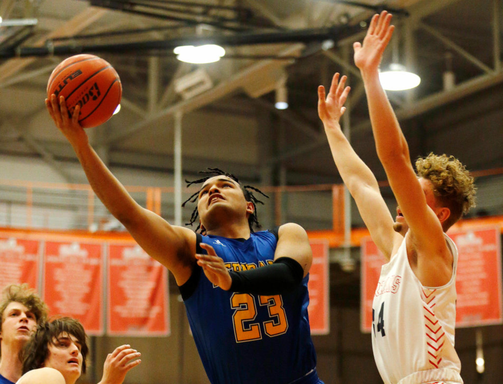 Ferndale’s Jazen Guillory drives through the paint and goes for a layup against Stanwood during a 3A District 1 Tournament semifinal game on Wednesday at Everett Community College. (Ryan Berry / The Herald)
