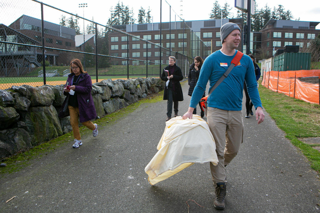 Jeff Brown of PAWS leads the way to a wetland before releasing a rehabilitated crow into the wild Friday at the UW Bothell campus. (Ryan Berry / The Herald)
