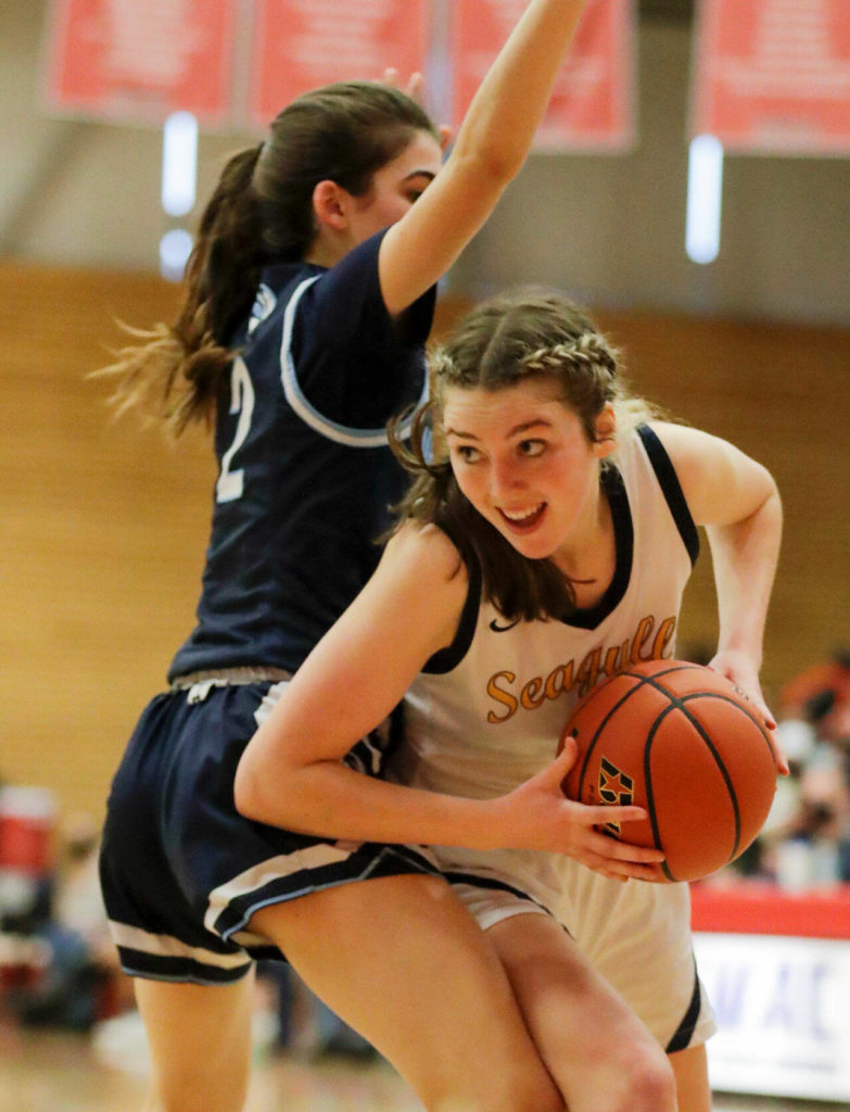 Everett’s Emma Larson looks for a score with Meadowdale’s Gia Powell defending Saturday afternoon at during the 3A District Tournament at Everett Community College in Everett, Washington on February 19, 2022. (Kevin Clark / The Herald )
