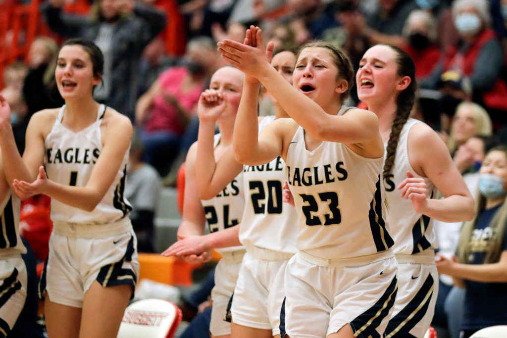 Arlington’s bench cheer the action of the floor against Stanwood Saturday evening at during the 3A District 1 Title game at Everett Community College in Everett, Washington on February 19, 2022. (Kevin Clark / The Herald )
