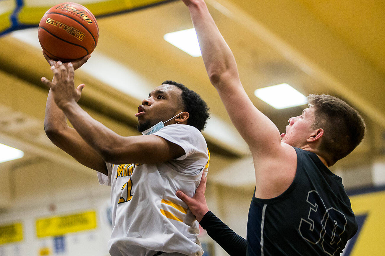 Mariner’s Naser Motley is able to get around Glacier Peak’s Bobby Siebers to make a layup during the game on Tuesday, Jan. 25, 2022 in Everett, Washington. (Olivia Vanni / The Herald)