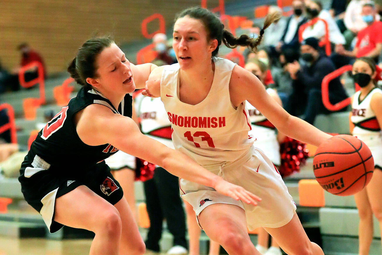 Snohomish’s Ella Gallatin drives the baseline with Mountlake Terrace’s Cameron Dunn defending Saturday afternoon at during the 3A District Tournament at Everett Community College in Everett, Washington on February 19, 2022. (Kevin Clark / The Herald )