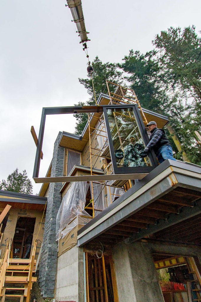 A construction crew prepares to install a window at a South Whidbey site. (Dave Welton)
