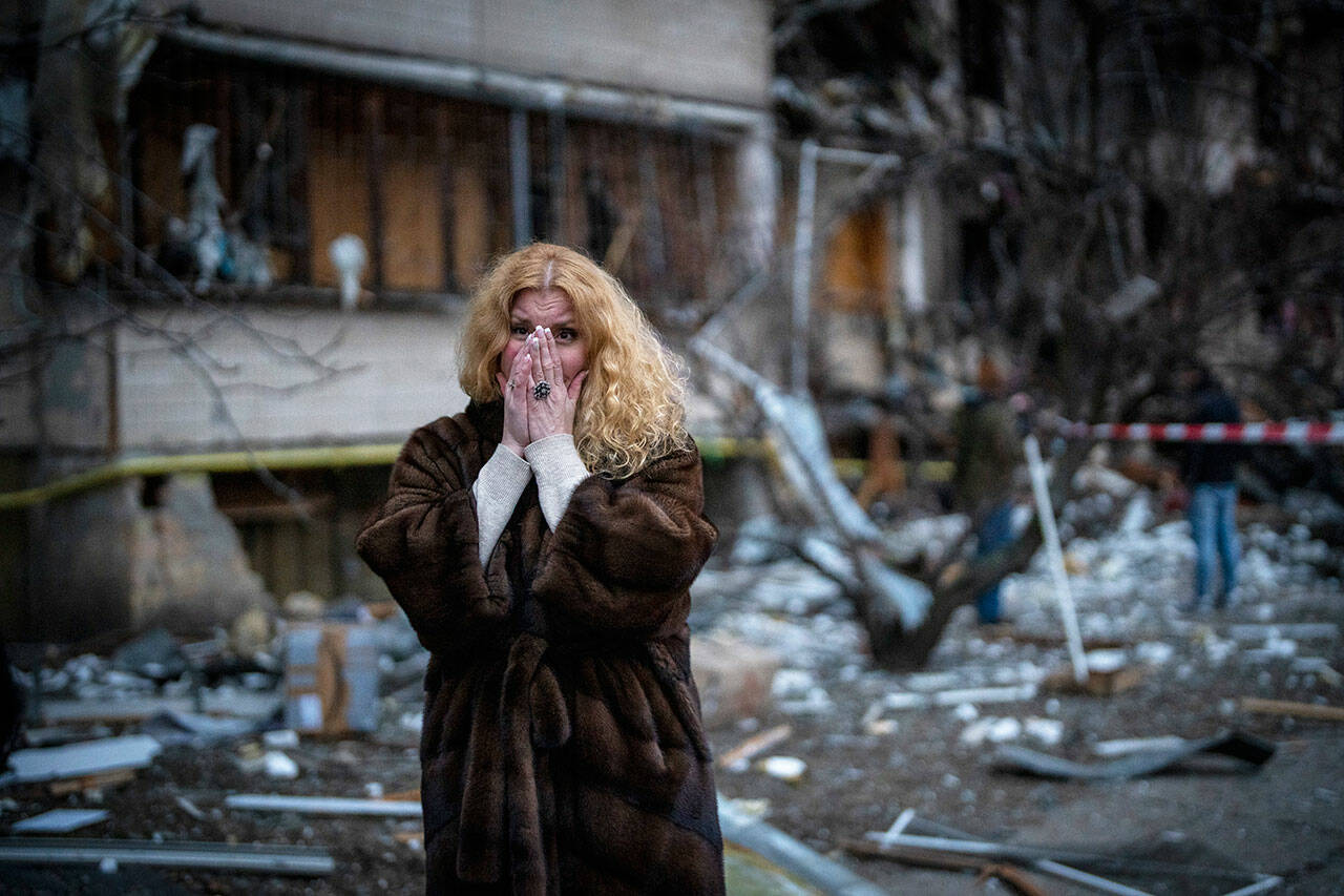 Natali Sevriukova reacts as she stands next to her house following a rocket attack in the city of Kyiv, Ukraine, Friday. (Emilio Morenatti / Associated Press)