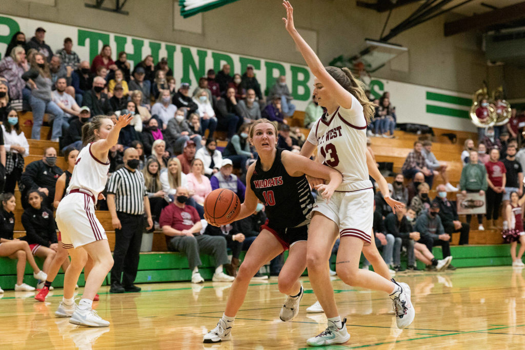 Archbishop Murphy guard Hannah Humphrey drives past W.F. West’s Drea Brumfield during a 2A state tournament game on Feb. 25, 2022, at Tumwater high School. (Alec Dietz / The Chronicle)
