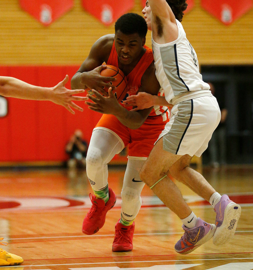 Graham-Kapowsin’s Elijah Cain tries to drive past a defender against Glacier Peak Saturday, Feb. 26, 2022, during a Class 4A regional matchup at Everett Community College in Everett, Washington. (Ryan Berry / The Herald)
