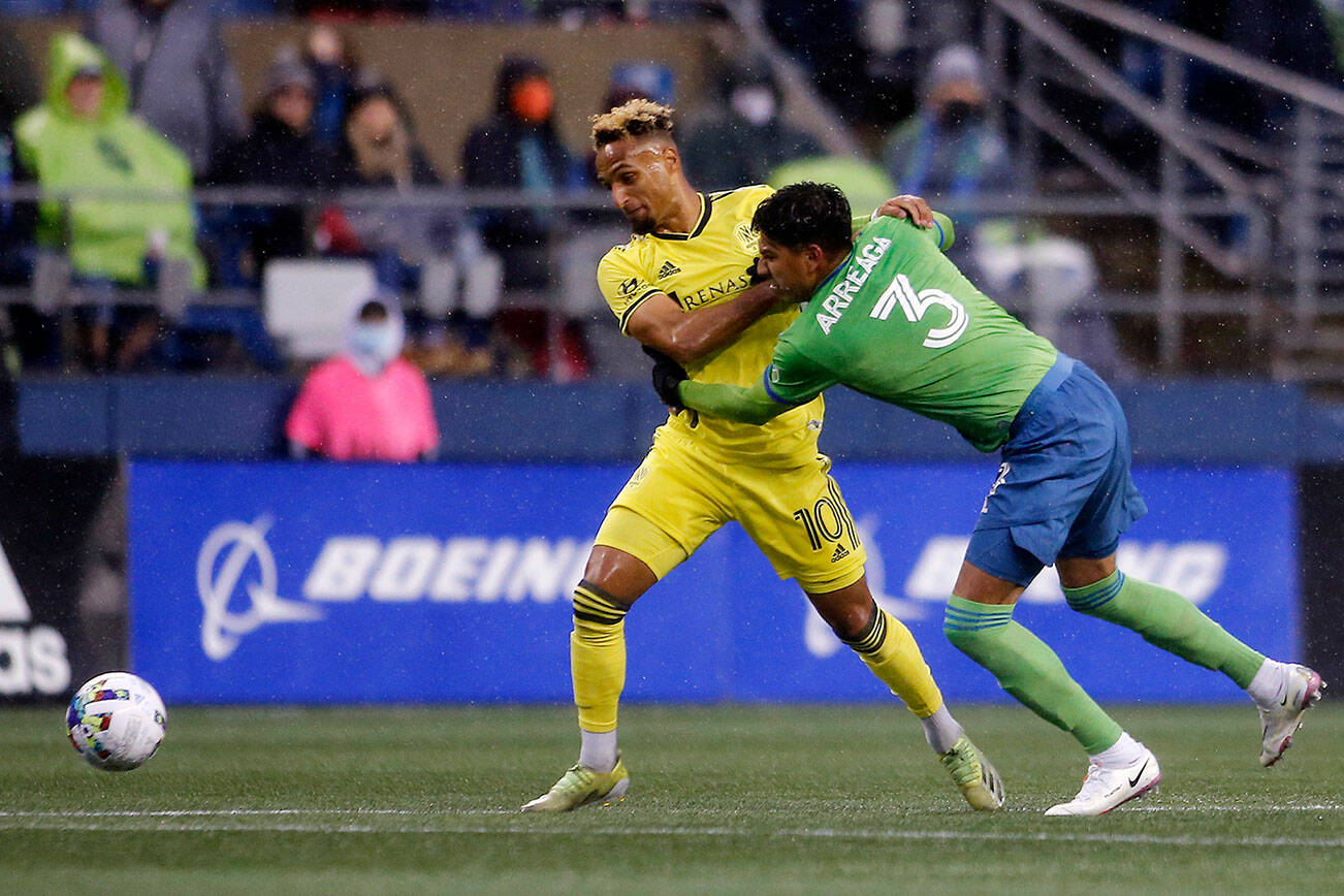 The Seattle Sounders’ Xavier Arreaga fights with Nashville’s Hany Mukhtar for the ball during the opening game of the 2022 season against Nashville SC on Sunday, Feb. 27, 2022, at Lumen Field in Seattle, Washington. (Ryan Berry / The Herald)