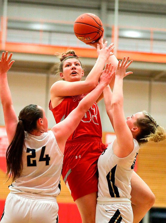 Stanwood’s Vivienne Berrett attempts a shot over the Arlington defense during the Class 3A District 1 title game at Everett Community College on Feb. 19. (Kevin Clark / The Herald )