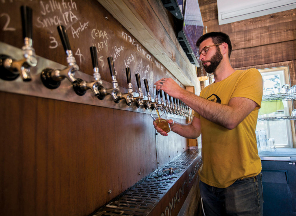 Ian Pope fills a glass from Penn Cove’s large selection of beer on tap. (Olivia Vanni / The Herald)
