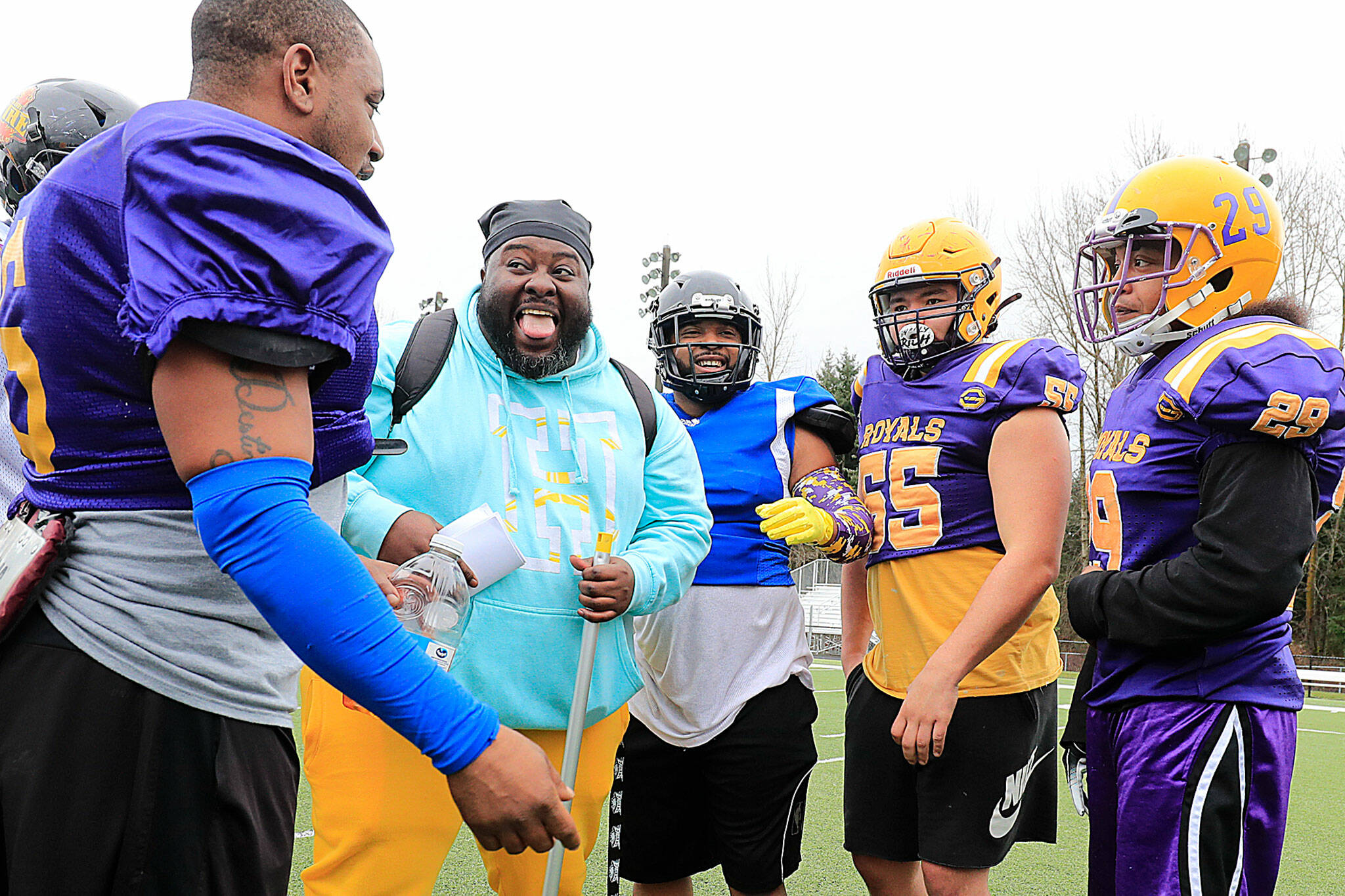 Boyd Demus, Everett Royals defensive coordinator, leads the huddle with a laugh at Archbishop Murphy High School. (Kevin Clark / The Herald)