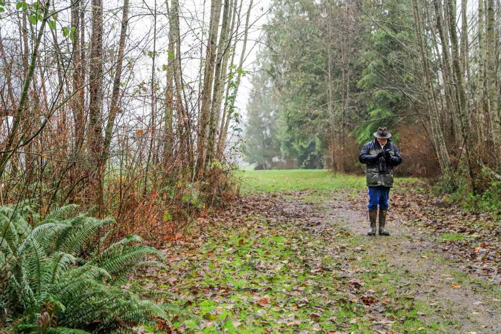 Rick Taylor enters the birds found on a smartphone along the trail. (Kevin Clark / The Herald)
