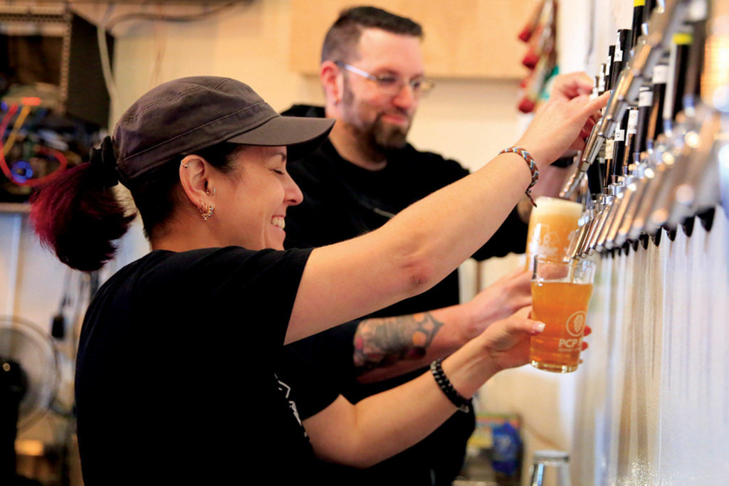 Mikki Burkholder and Sean Seifert pull pints at 5 Rights’ expanded location in Marysville. (Kevin Clark / The Herald)

