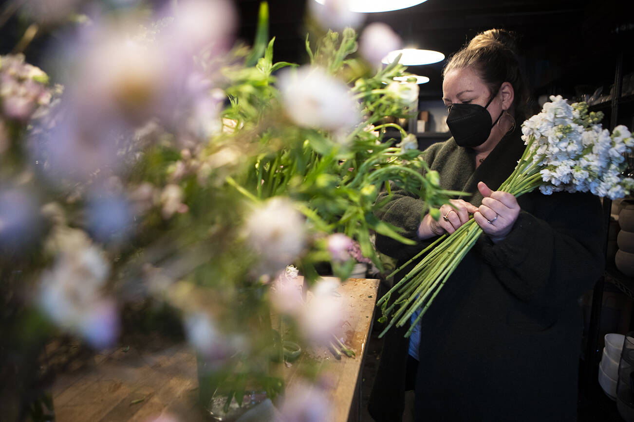 FIELD co-owner Liz Morgan processes flowers at their shop in Edmonds on Wednesday, March 2, 2022. (Olivia Vanni / The Herald)